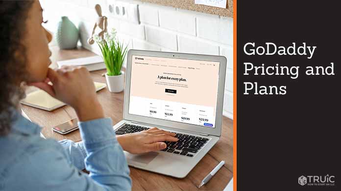 Woman looking at GoDaddy plans and pricing on laptop.