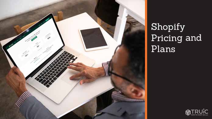 Person on laptop looking at Shopifys pricing and plans.