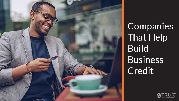 Businessman at laptop with credit card.