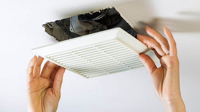 A person removing an air duct plate