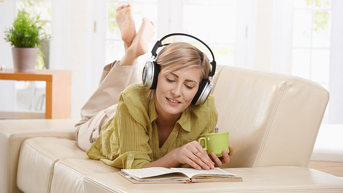 A woman listening to an audiobook while reading