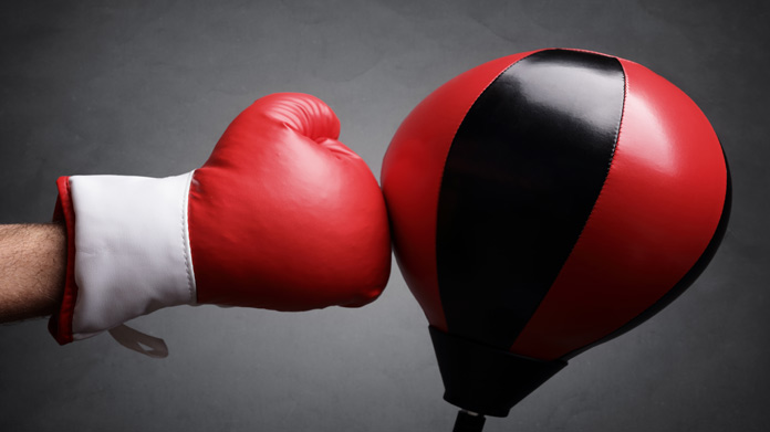 A boxing glove hitting a boxing dummy