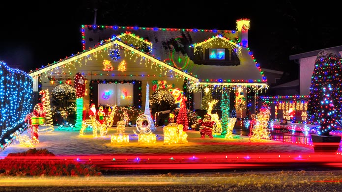 A house and lawn covered in light-up Christmas decorations
