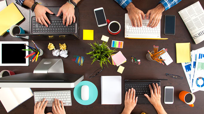 Four people working on their laptops in a creative agency