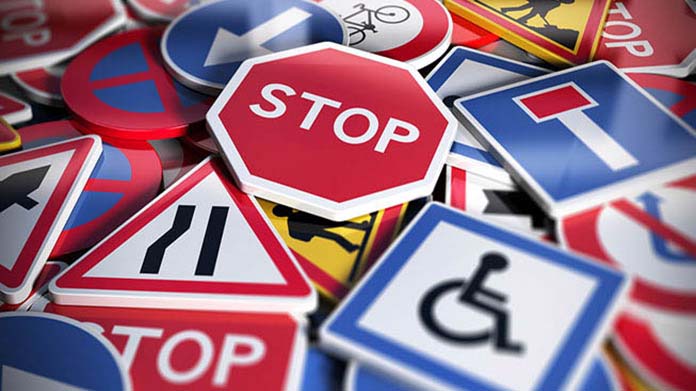A variety of traffic signs in a pile