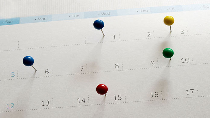 Pins stuck in various dates of a calendar