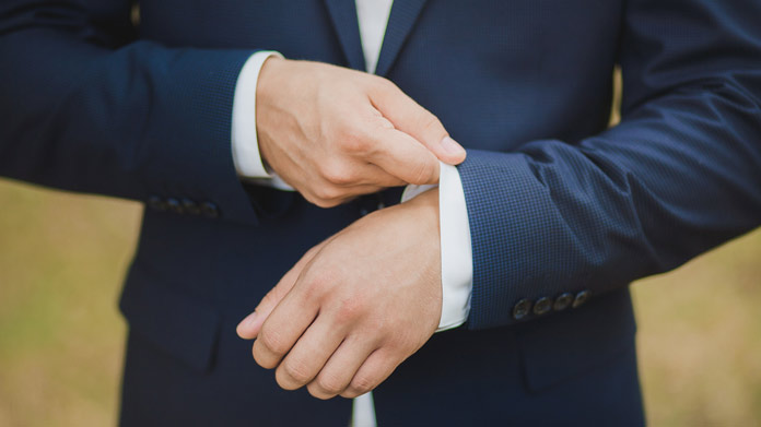 A man adjusting his suit sleeve