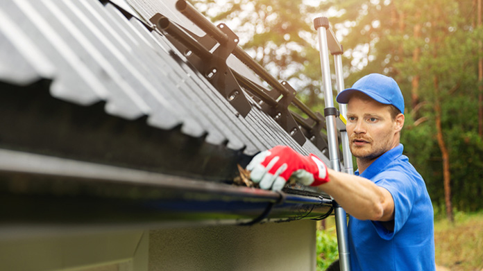A man cleaning a gutter