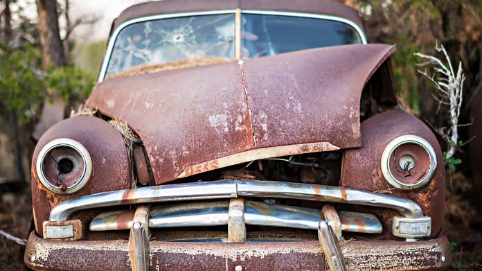 A rusted, broken old car