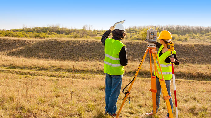 two people surveying land