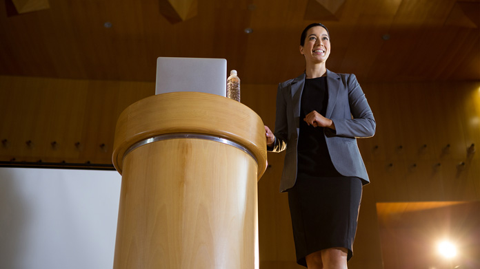 A woman giving a speech at a podium