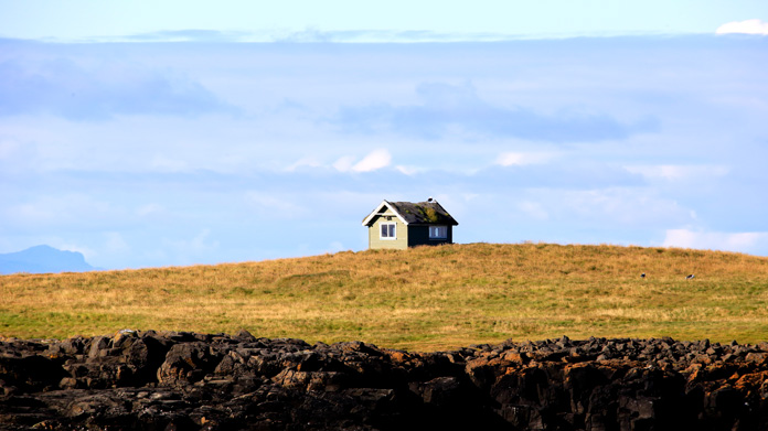 Landscape with a tiny house on a hill