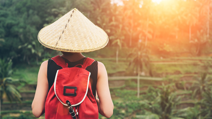 The back of a tour guide wearing a conical hat