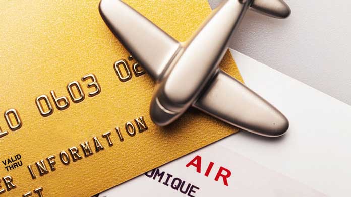 A model airplane sitting on top of two credit cards