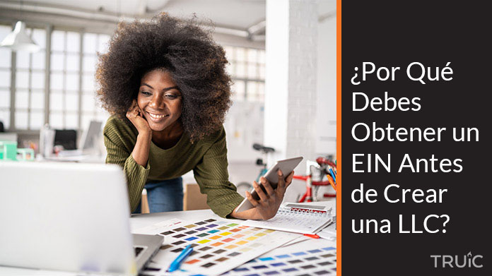 Una emprendedora en su oficina leyendo un artículo en la computadora sobre el EIN.