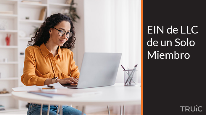 Mujer profesional trabajando en su computadora en su oficina con documentos de su empresa.