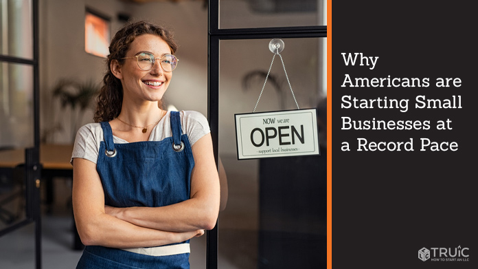 Business owner standing in doorway with an open sign.