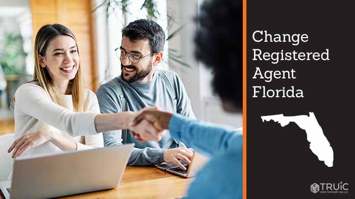 Couple meeting with registered agent, shaking hands.