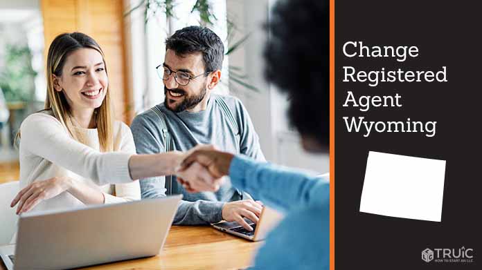 Couple meeting with registered agent, shaking hands.