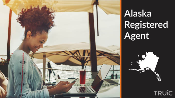 A person happily working remotely at a beach while their registered agent service takes care of business