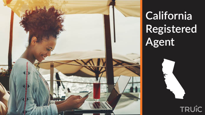 A person happily working remotely at a beach while their registered agent service takes care of business