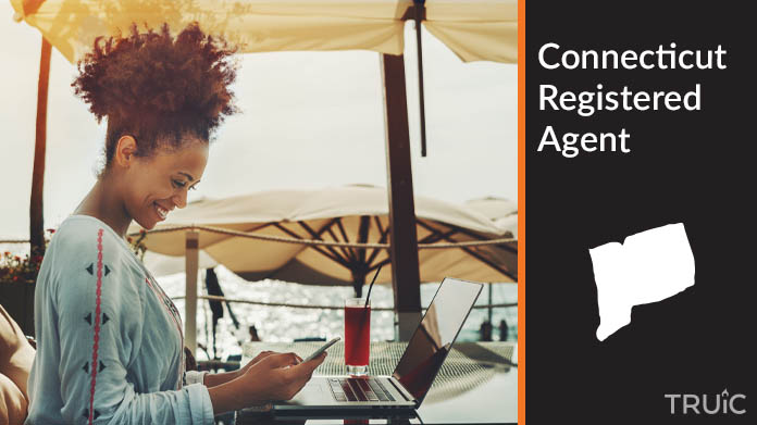 A person happily working remotely at a beach while their registered agent service takes care of business
