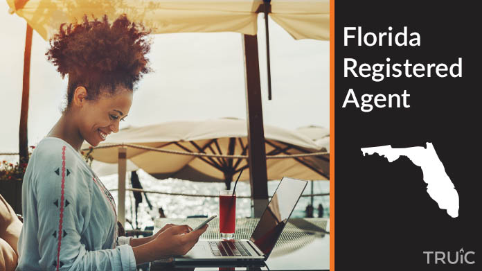 A person happily working remotely at a beach while their registered agent service takes care of business