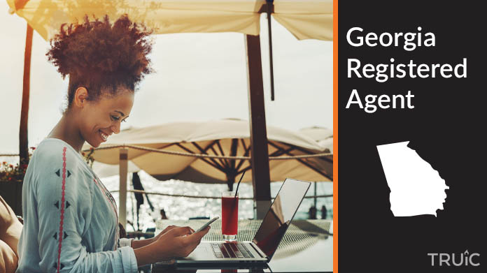 A person happily working remotely at a beach while their registered agent service takes care of business