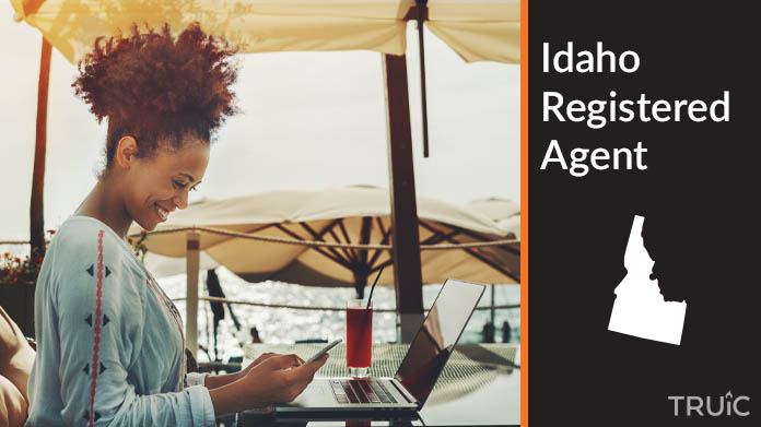 A person happily working remotely at a beach while their registered agent service takes care of business