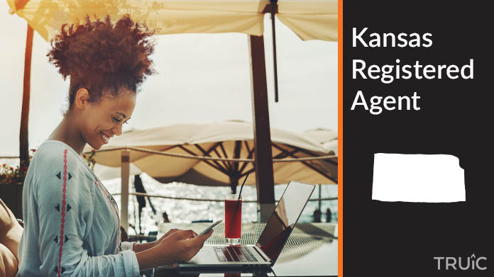 A person happily working remotely at a beach while their registered agent service takes care of business