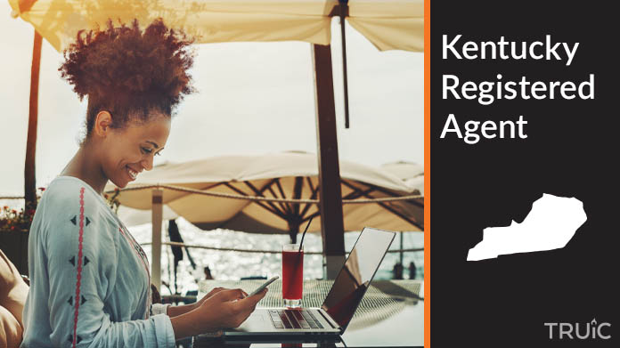 A person happily working remotely at a beach while their registered agent service takes care of business