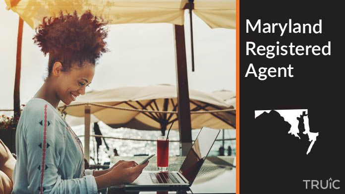 A person happily working remotely at a beach while their registered agent service takes care of business