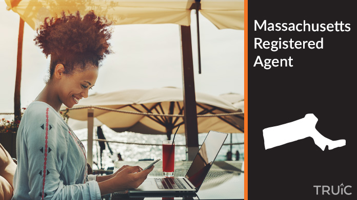 A person happily working remotely at a beach while their registered agent service takes care of business