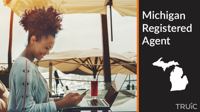A person happily working remotely at a beach while their registered agent service takes care of business