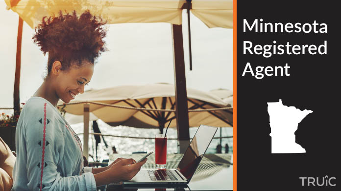 A person happily working remotely at a beach while their registered agent service takes care of business
