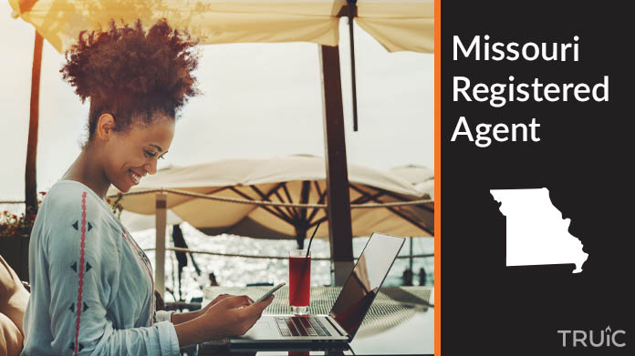 A person happily working remotely at a beach while their registered agent service takes care of business