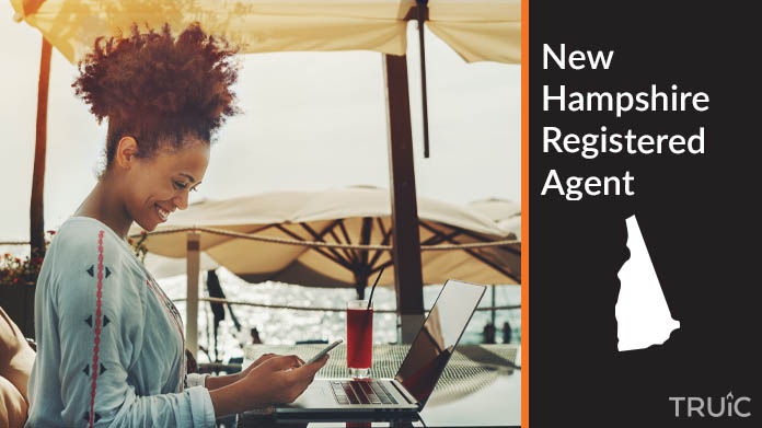 A person happily working remotely at a beach while their registered agent service takes care of business