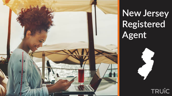 A person happily working remotely at a beach while their registered agent service takes care of business