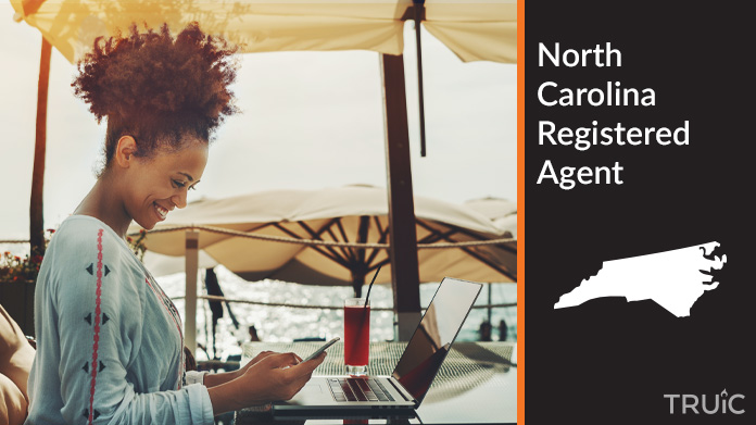A person happily working remotely at a beach while their registered agent service takes care of business