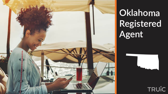 A person happily working remotely at a beach while their registered agent service takes care of business