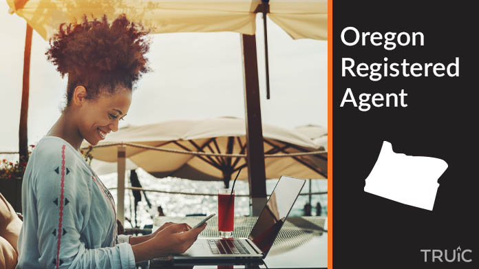 A person happily working remotely at a beach while their registered agent service takes care of business