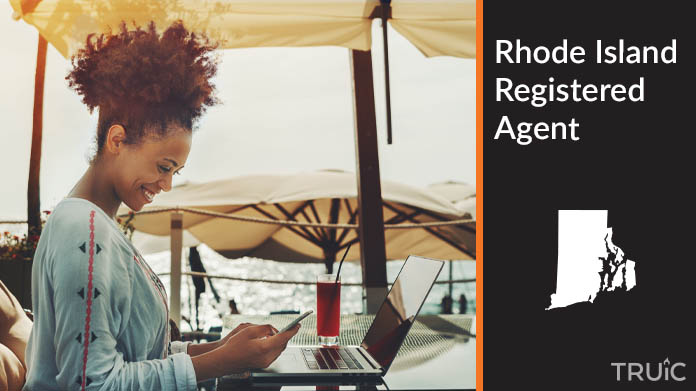 A person happily working remotely at a beach while their registered agent service takes care of business