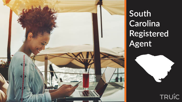 A person happily working remotely at a beach while their registered agent service takes care of business