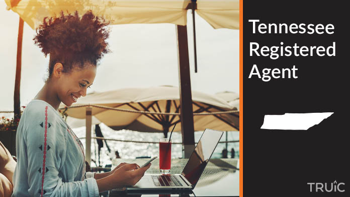 A person happily working remotely at a beach while their registered agent service takes care of business