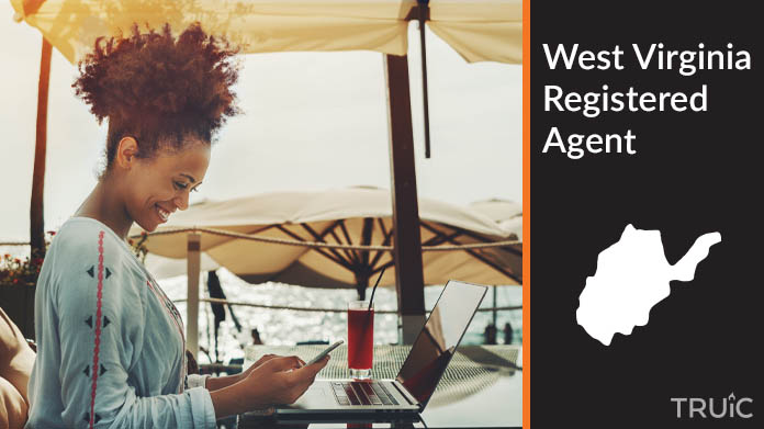 A person happily working remotely at a beach while their registered agent service takes care of business