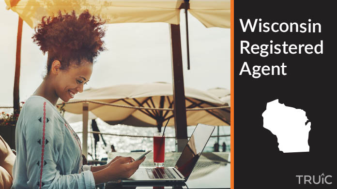 A person happily working remotely at a beach while their registered agent service takes care of business