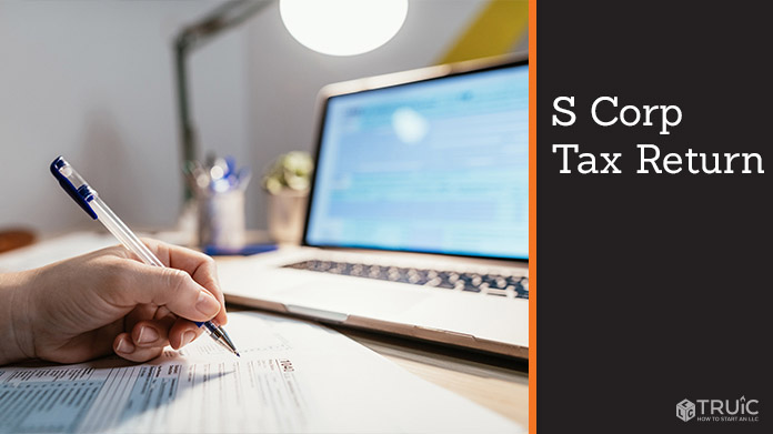 Person filling out tax forms in from of their laptop.